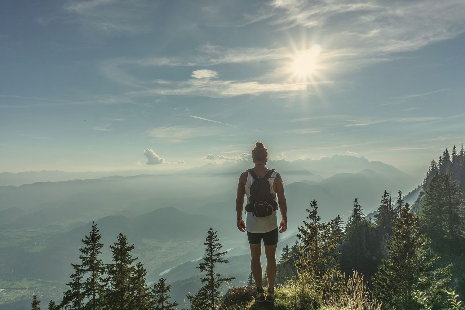 Cover of TANNED Issue 001: a hiker on a sunlit ridge above a valley.